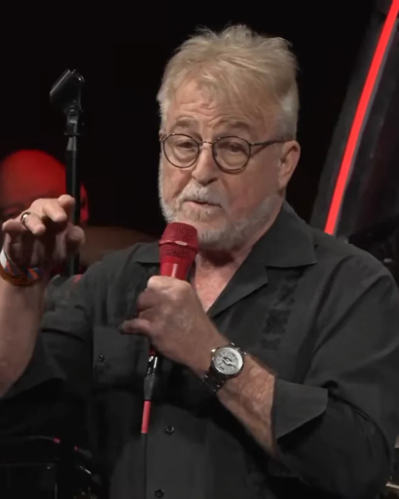 Uncle G on stage with a red microphone