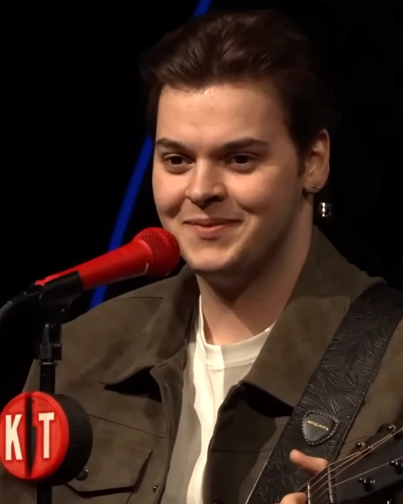 Tony Scar smiling at the microphone with his guitar