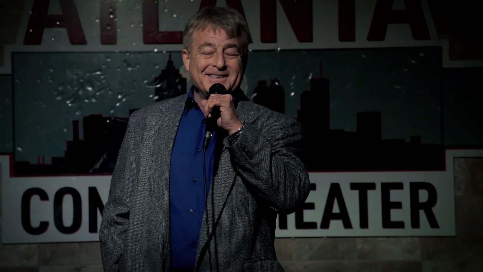 Greg Langford at the mic under the Atlanta Comedy Theater sign