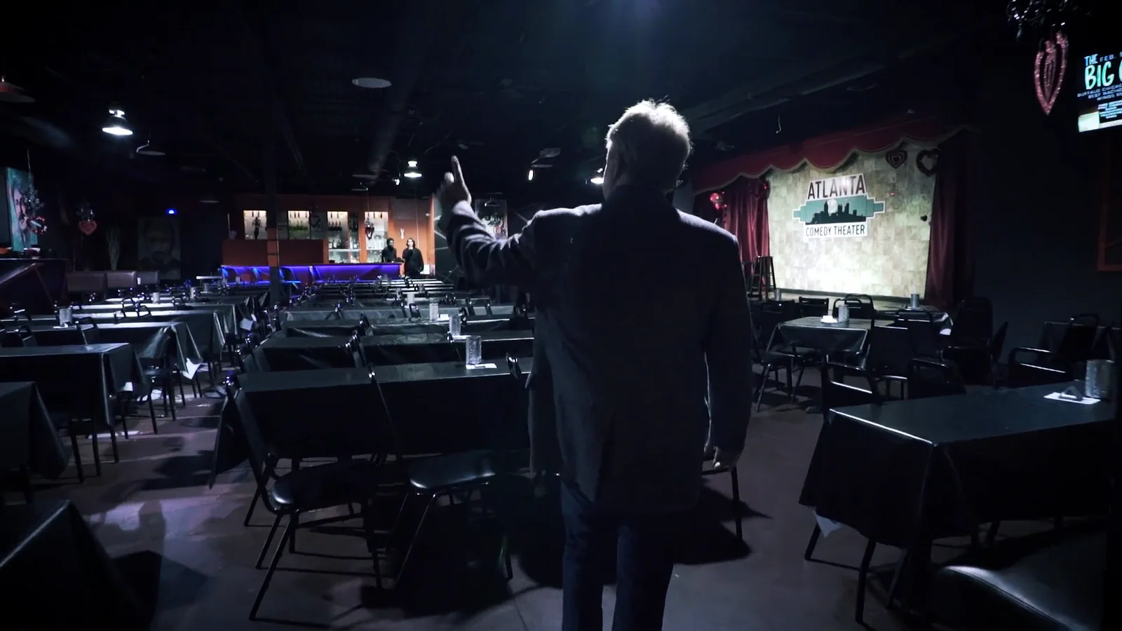 Greg Langford alone on stage looking out at an empty comedy club