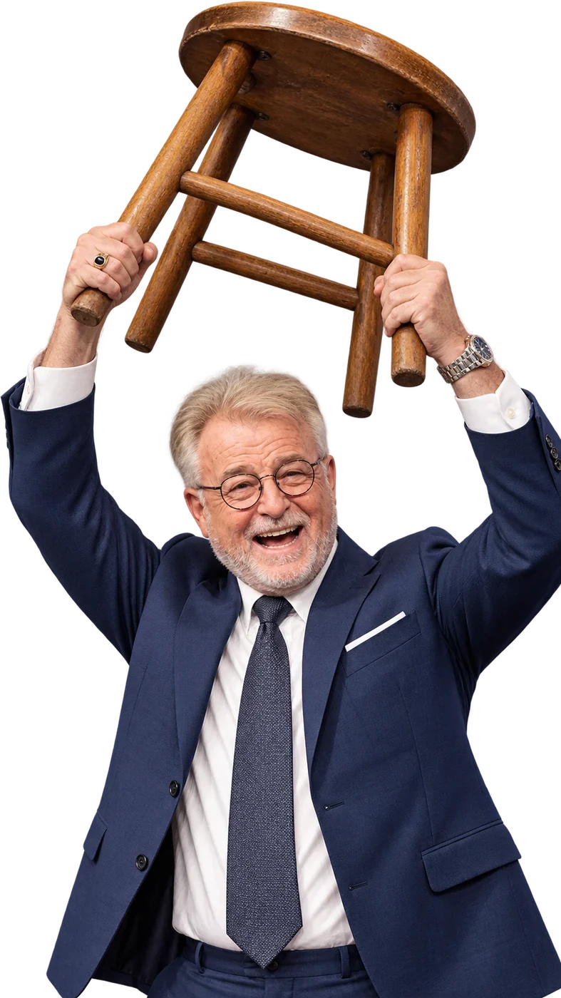 Uncle G in a navy suit, laughing, holding a bar stool over his head