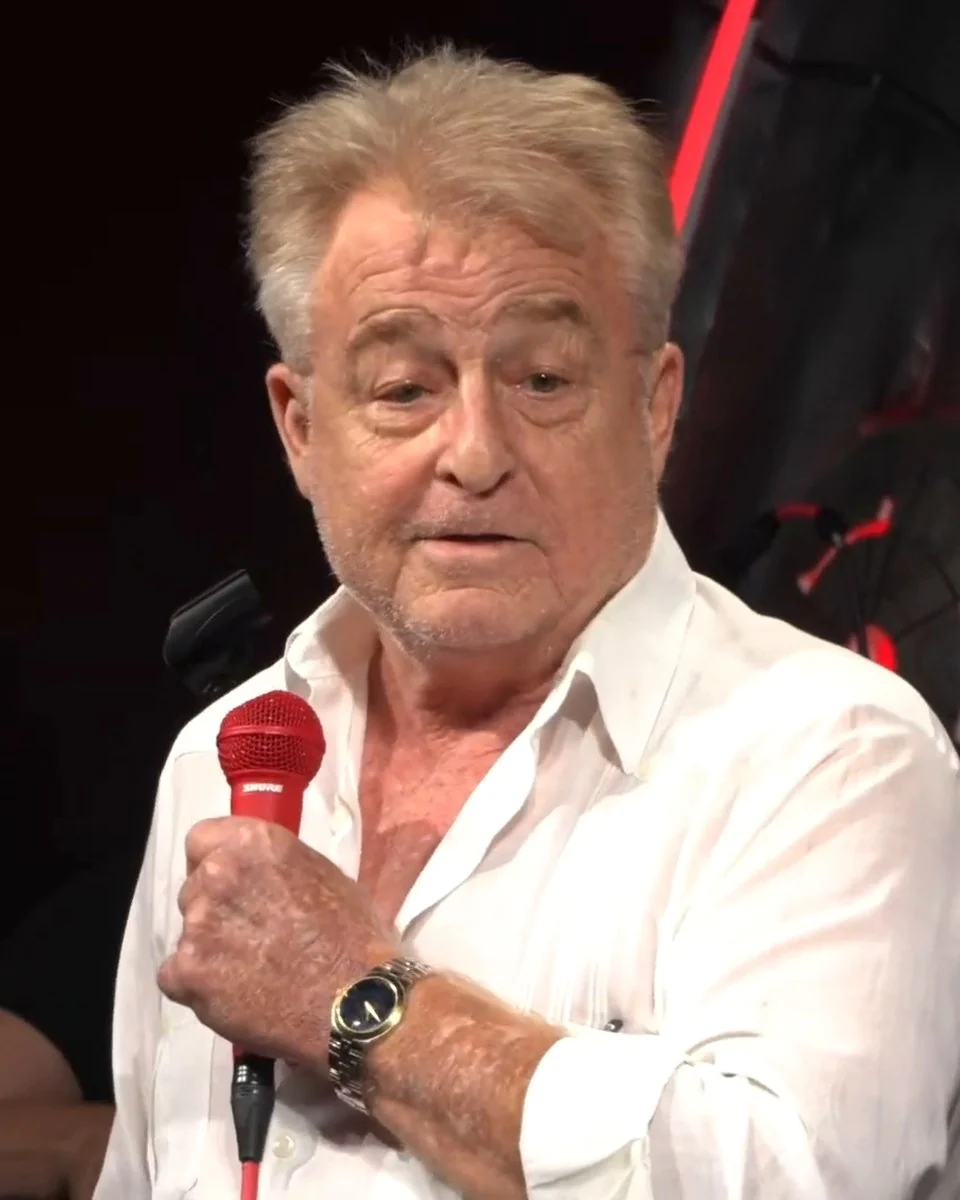 Uncle G in a white shirt with a red microphone