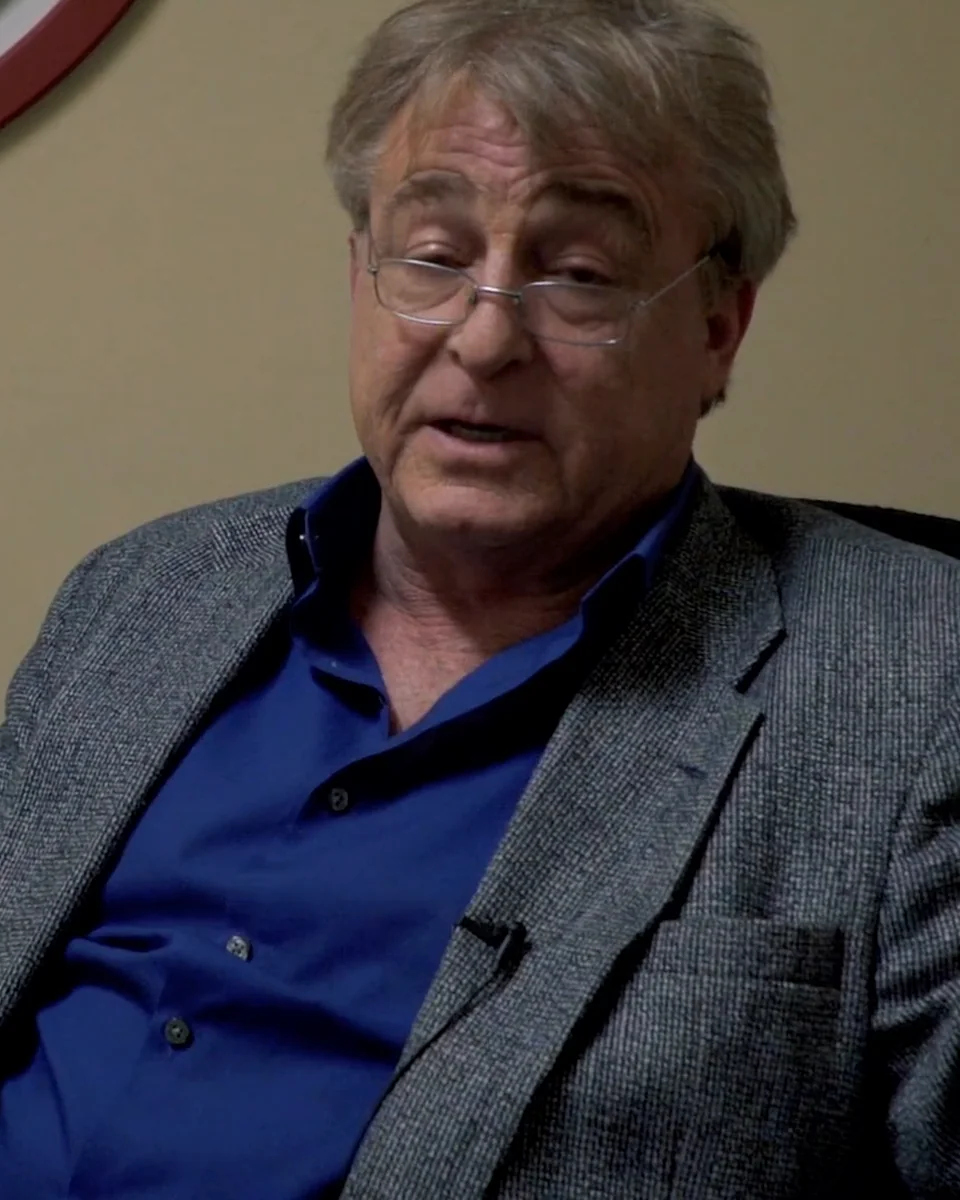 Greg Langford in a blazer, mid-interview