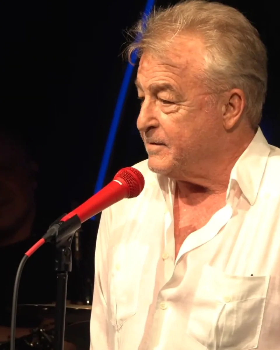 Uncle G in blue stage light at the microphone