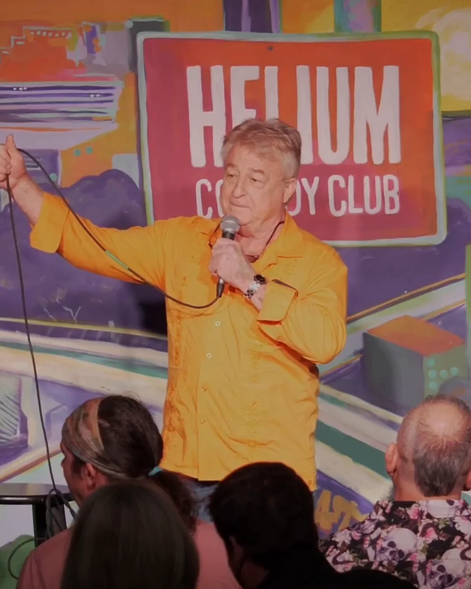Uncle G in an orange shirt at Helium Comedy Club
